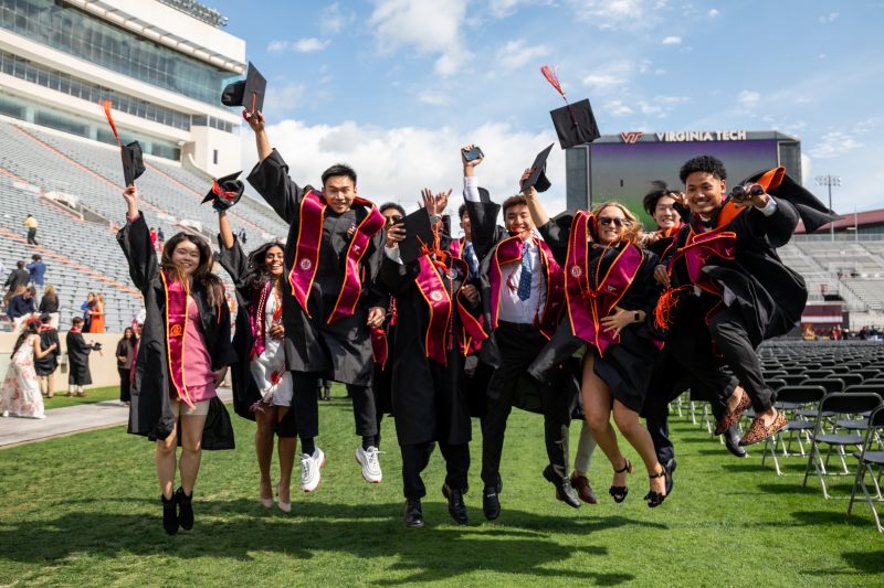 students jumping at graduation